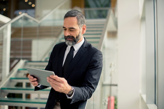 Bonito, homem negócios sênior, com, tablete digital, em, a, modren, escritório