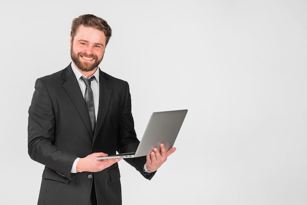 Bonito, homem negócios, usando computador portátil, e, sorrindo