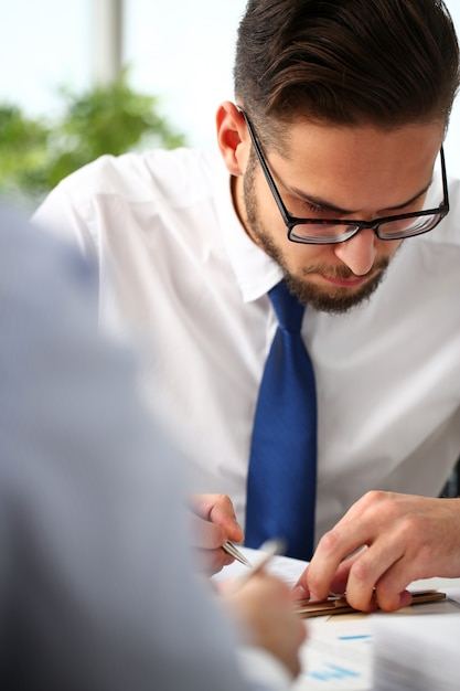 Bonito homem sorridente balconista no local de trabalho de escritório