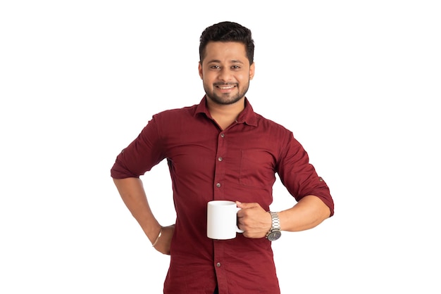 Bonito homem sorridente com uma xícara de café ou chá isolado no fundo branco