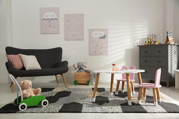 Bonito interior de habitación infantil con sofá y mesita.