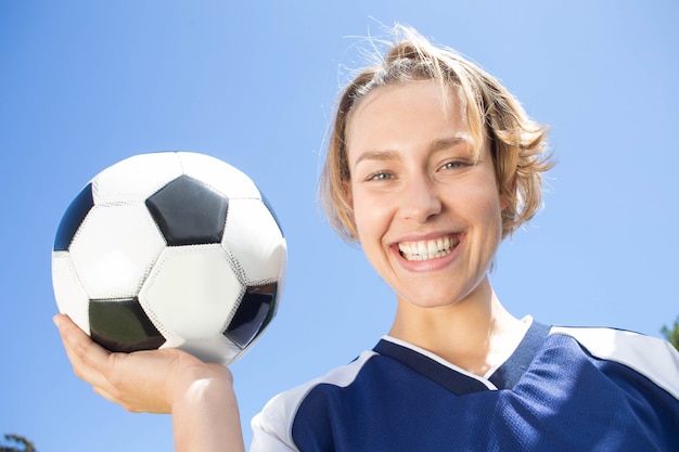 Bonito jogador de futebol sorridente da câmera