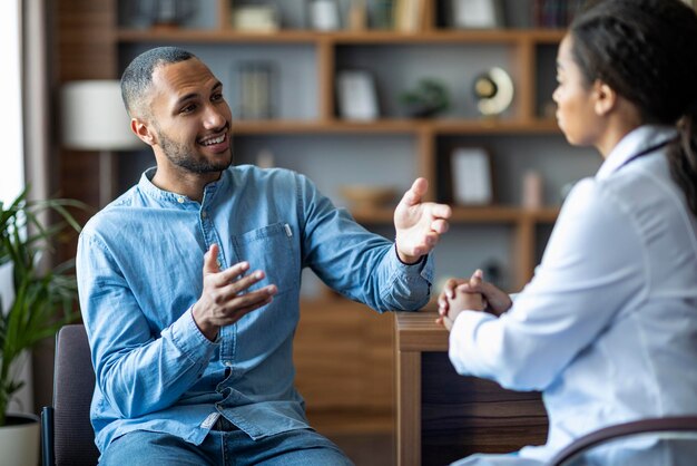 Bonito jovem afro-americano tendo consulta com o médico