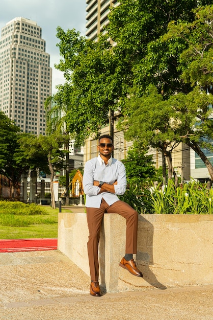 Bonito jovem empresário negro no parque ao ar livre durante o verão