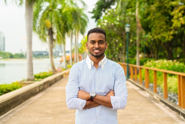 Bonito jovem empresário negro no parque ao ar livre durante o verão