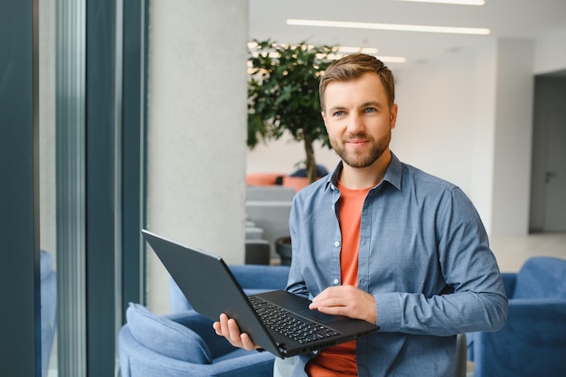 Bonito jovem empresário usando um laptop no café