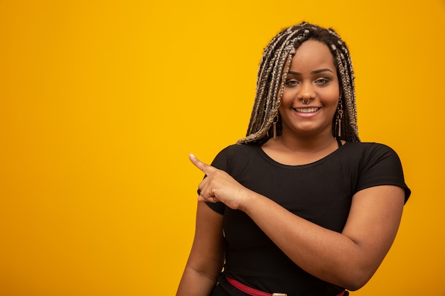 Bonito, jovem, mulher americana africana, com, cabelo temor, apontar dedo, ligado, amarela