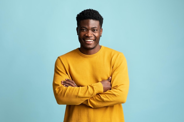 Bonito jovem negro posando sozinho em azul