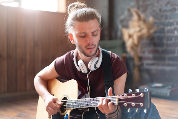 Bonito jovem tocando violão