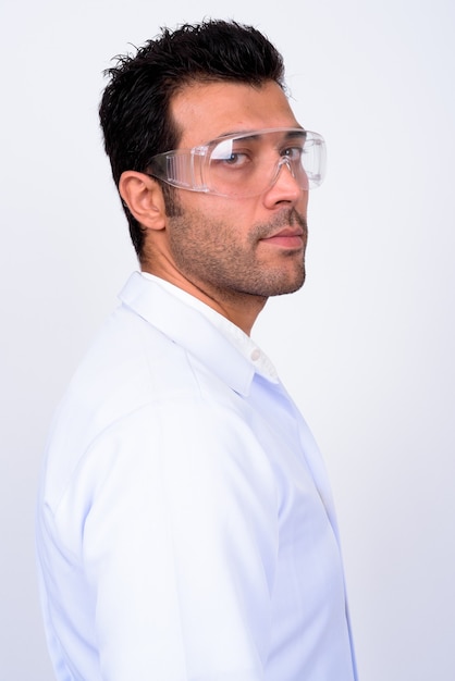 Bonito médico turco usando óculos de proteção contra uma parede branca