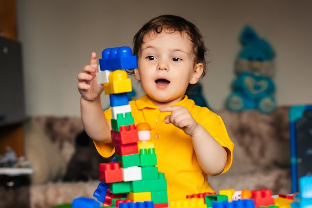 Bonito menino criança brincando em casa com cubos coloridos