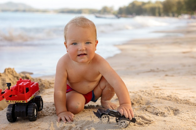 Bonito menino infantil brincando na praia