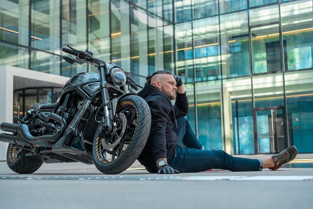 Bonito motociclista em sua moto andando na cidade Foto de alta qualidade