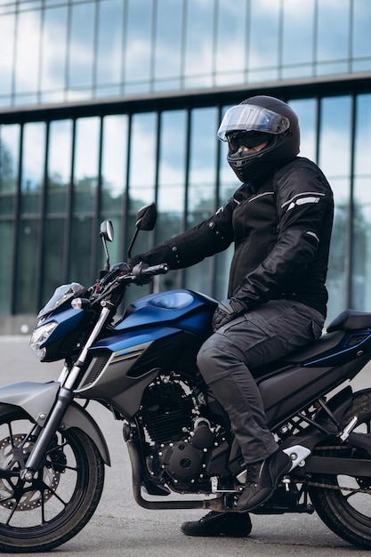 Bonito motociclista em sua moto andando na cidade