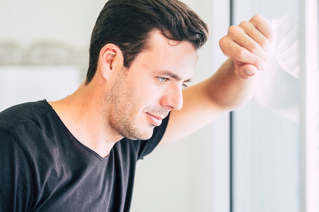 bonito olhos azuis lindos caucasianos cabelo preto modelo homem olhar pela janela perdido em seus pensamentos