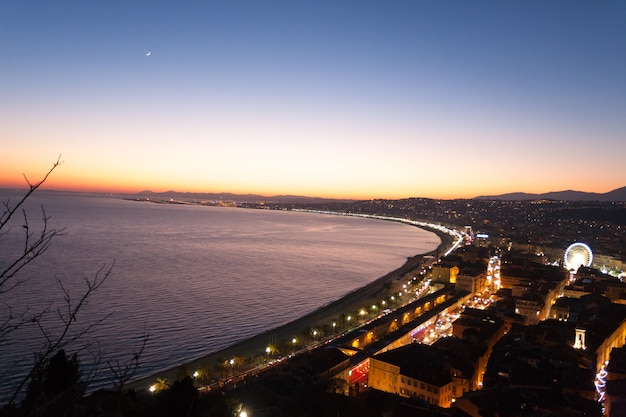 Bonito paisaje nocturno de playa, Francia. Bonita playa y famoso Paseo de los Ingleses, Promenade des Anglais. Famosa ciudad turística francesa