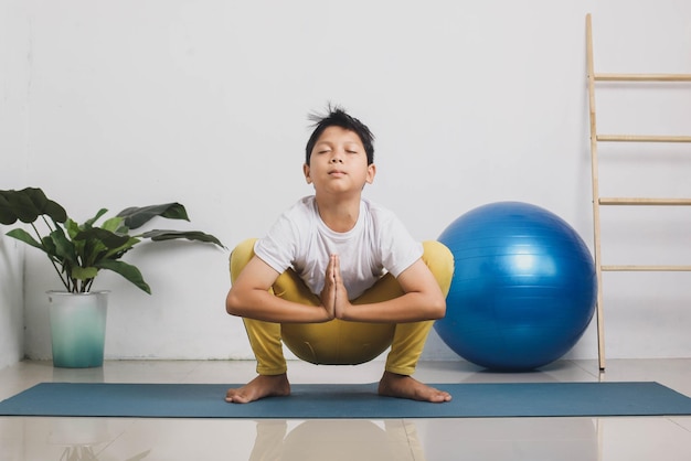 Bonito rapaz asiático está meditando em casa