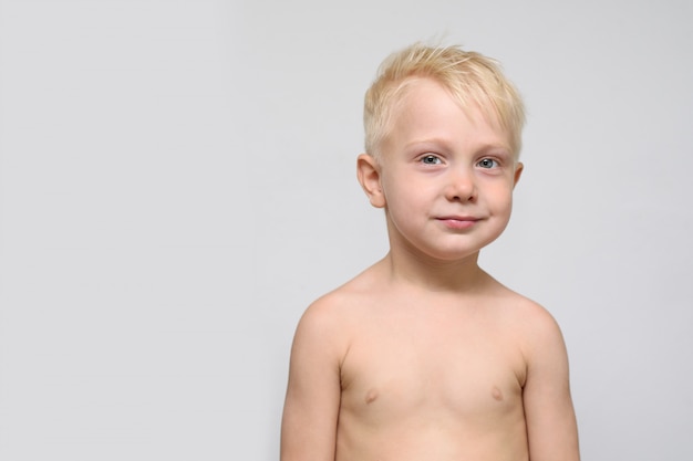 Bonito rapaz loiro sorridente sem camisa. Retrato. Espaço para texto. fundo branco