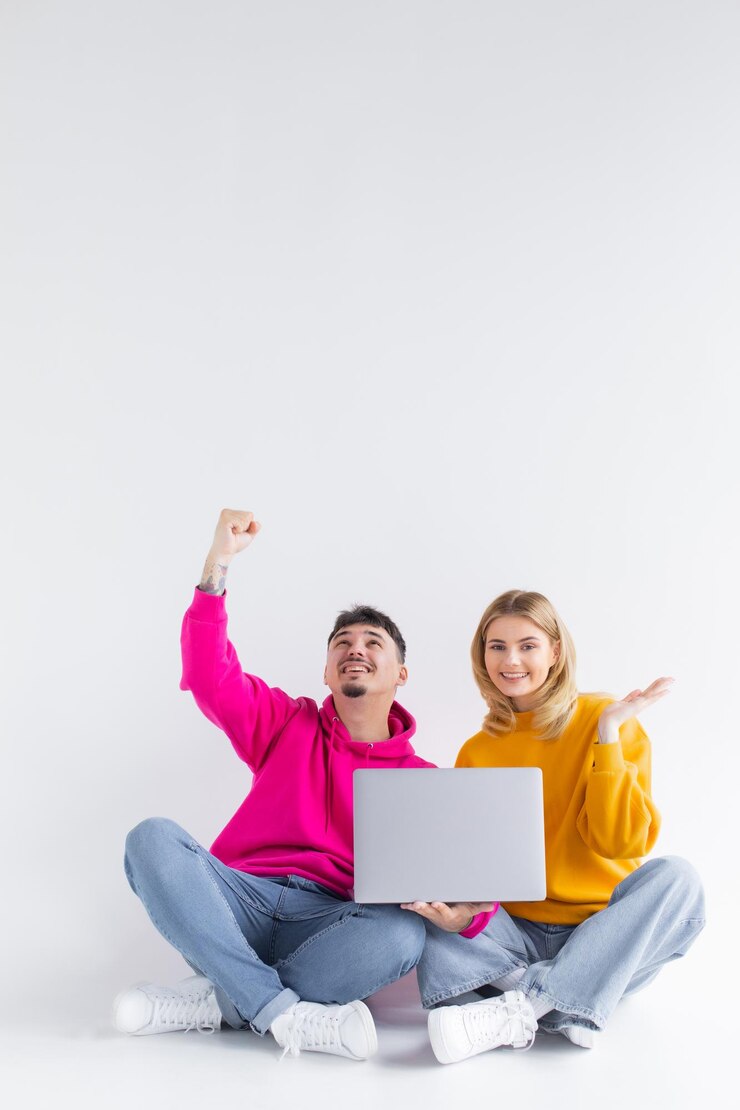 Bonito retrato de pareja con portátil sentado fondo gris