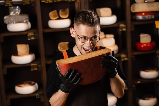 Bonito sommelier de queijo segurando e brinca com queijo gouda limitado Lanche saboroso pedaço de queijo para aperitivo Homem faminto