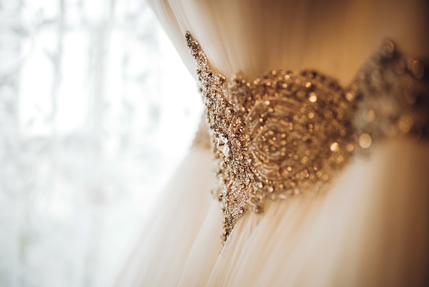 Bonito vestido de novia blanco colgado en la habitación de la novia.