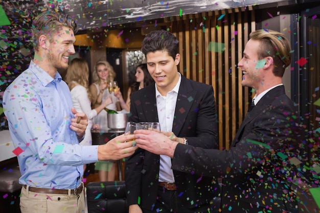 Bonitos amigos tomando uma bebida juntos contra cores vivas