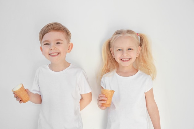 Bonitos crianças comendo sorvete no fundo branco