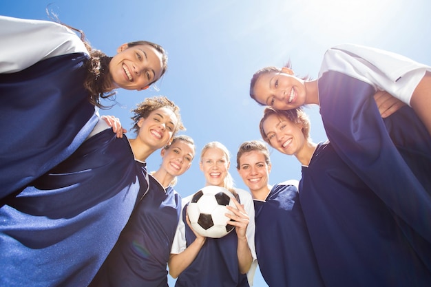 Bonitos jogadores de futebol sorrindo para a câmera