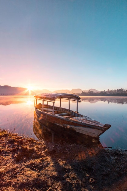 Boot am See bei Sonnenuntergang vor klarem Himmel