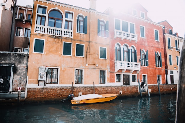 Boot auf kleinem Kanal machte gegen altes buntes Backsteinhaus in Venedig, Italien fest.