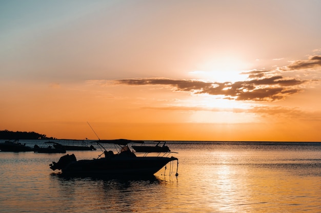 Boot bei Sonnenuntergang im Indischen Ozean vor der Küste von Mauritius.