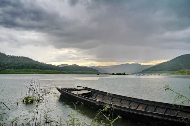 Boot, das am See gegen die Berge verankert ist