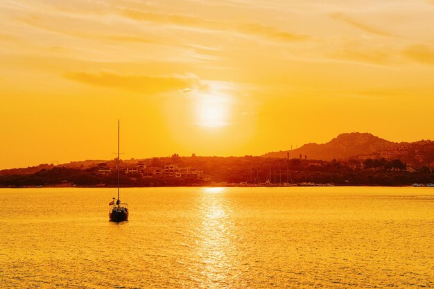 Boot in Porto Rotondo am Mittelmeer an der Costa Smeralda auf Sardinien in Italien bei Sonnenaufgang