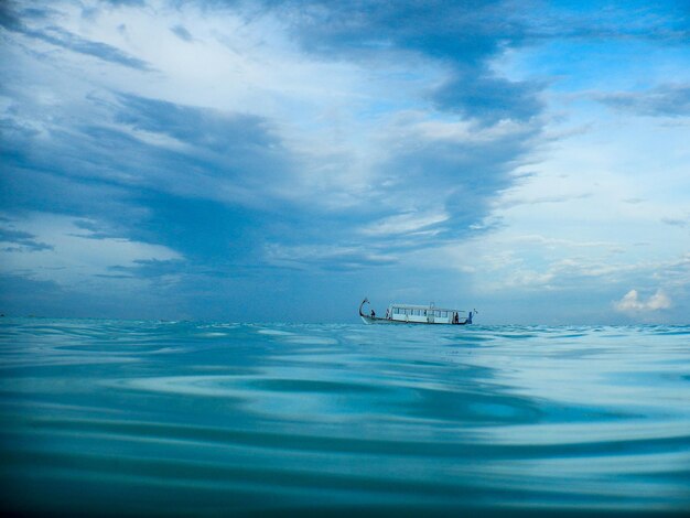 Foto boot segelt im blauen meer gegen einen bewölkten himmel