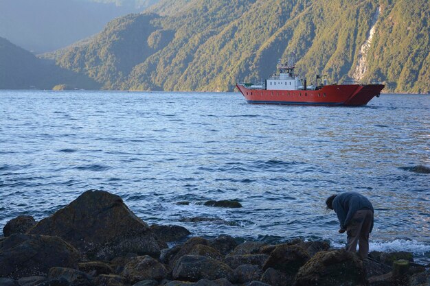 Boot überquert einen See mit Bergen im Hintergrund