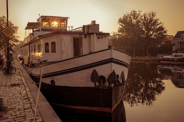 Boot verankert an einem Kanal in Amsterdam bei Sonnenaufgang