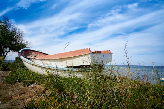 Foto boot verankert auf dem gras am meer gegen den himmel