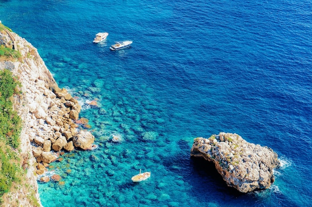 Boote auf der Insel Capri in der Nähe von Neapel in Italien. Landschaft mit blauem Mittelmeer an der italienischen Küste. Panorama von Anacapri in Europa. Im Sommer ansehen. Schöne Landschaft von Amalfi und Berg Solaro