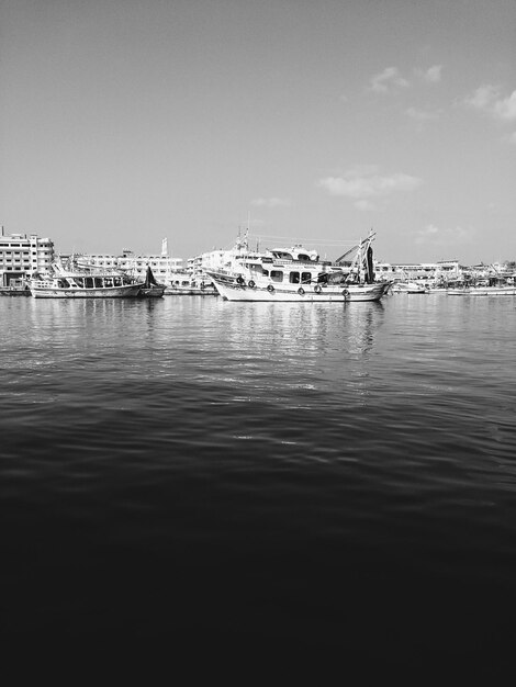 Foto boote, die am dock verankert sind, mit der stadt im hintergrund