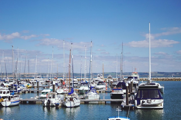 Boote, die am Hafen im Fluss gegen den Himmel verankert sind
