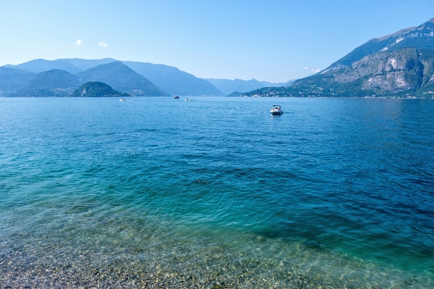 Boote, die auf azurblauem Wasser des Comer Sees kreuzen