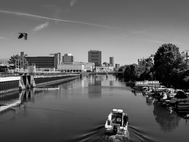 Foto boote im fluss nach stadt gegen den himmel