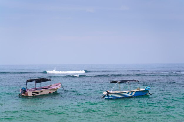 Boote im Meer mit einer Welle im Hintergrund