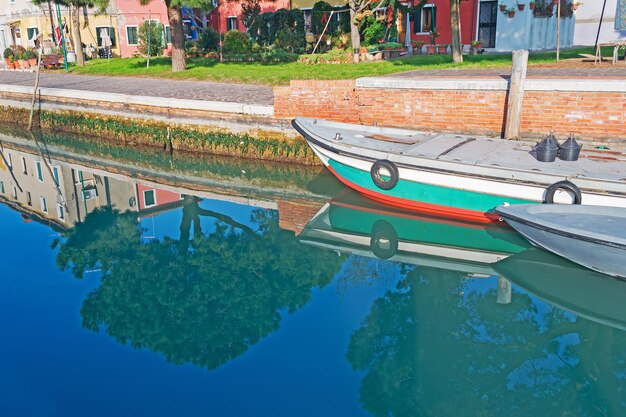 Boote und Bäume spiegeln sich in der Lagune von Venedig wider