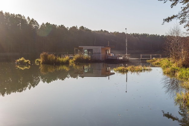 Bootssteghaus auf Holzsteg im Wasser im Wald am Abend