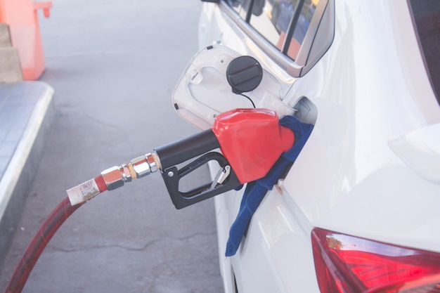 Boquilla de combustible verde para recargar combustible en el automóvil en una estación de servicio.