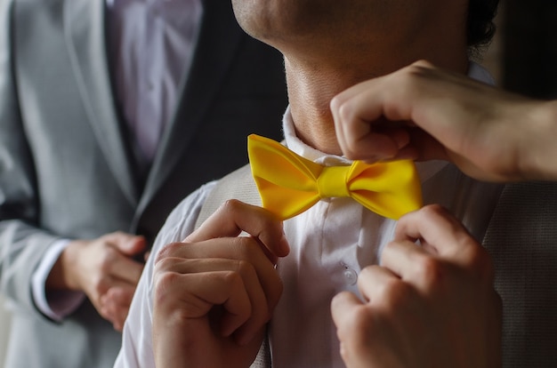 Borboleta de gravata amarela no pescoço de um homem