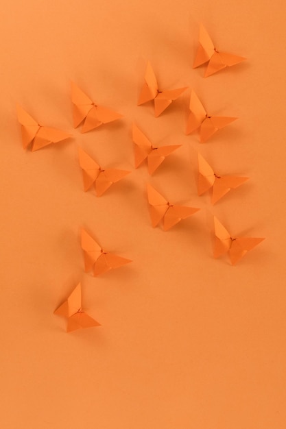 Borboleta de origami laranja em fundo laranja