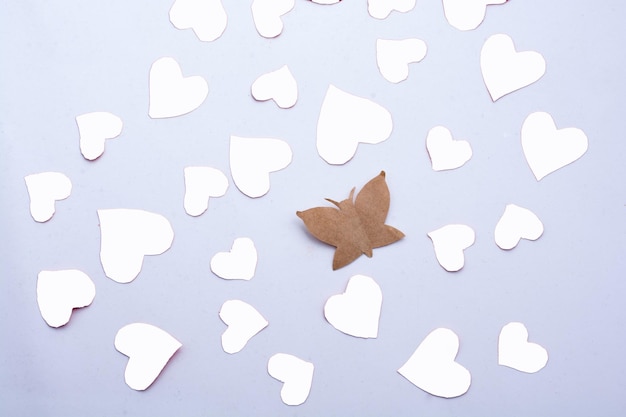 Borboleta de papel e corações de papel em vermelho