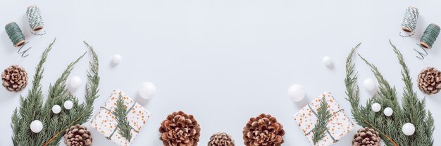 Borda mínima de Natal branca com galho de árvore de Natal, decoração e cones, configuração plana, espaço de cópia, banner da web